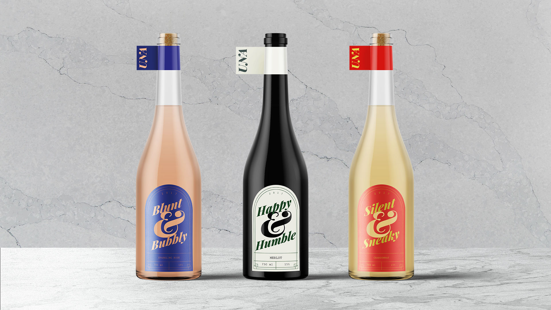 Three wine bottle sitting on a marble counter with a marble background. Bottle on the left is a rose and the bottle has a curved blue label that says blunt and bubbly. Middle bottle is black with a light green label that says happy and humble. Right bottle is a Chardonnay wine with a red label that says silent and sneaky. All labels have a laser cut ampersand sign cut out in the centre.