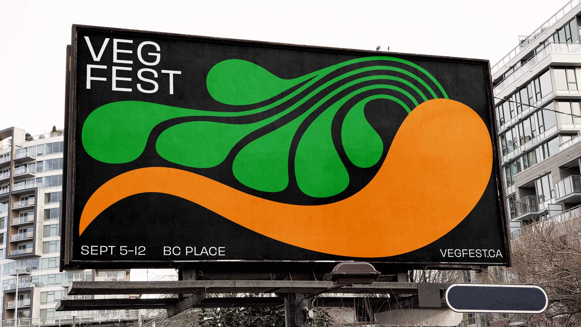A big billboard with a highly stylized illustration of a carrot on a black background. The billboard text reads “Veg Fest. Sept 5-12. BC Place”