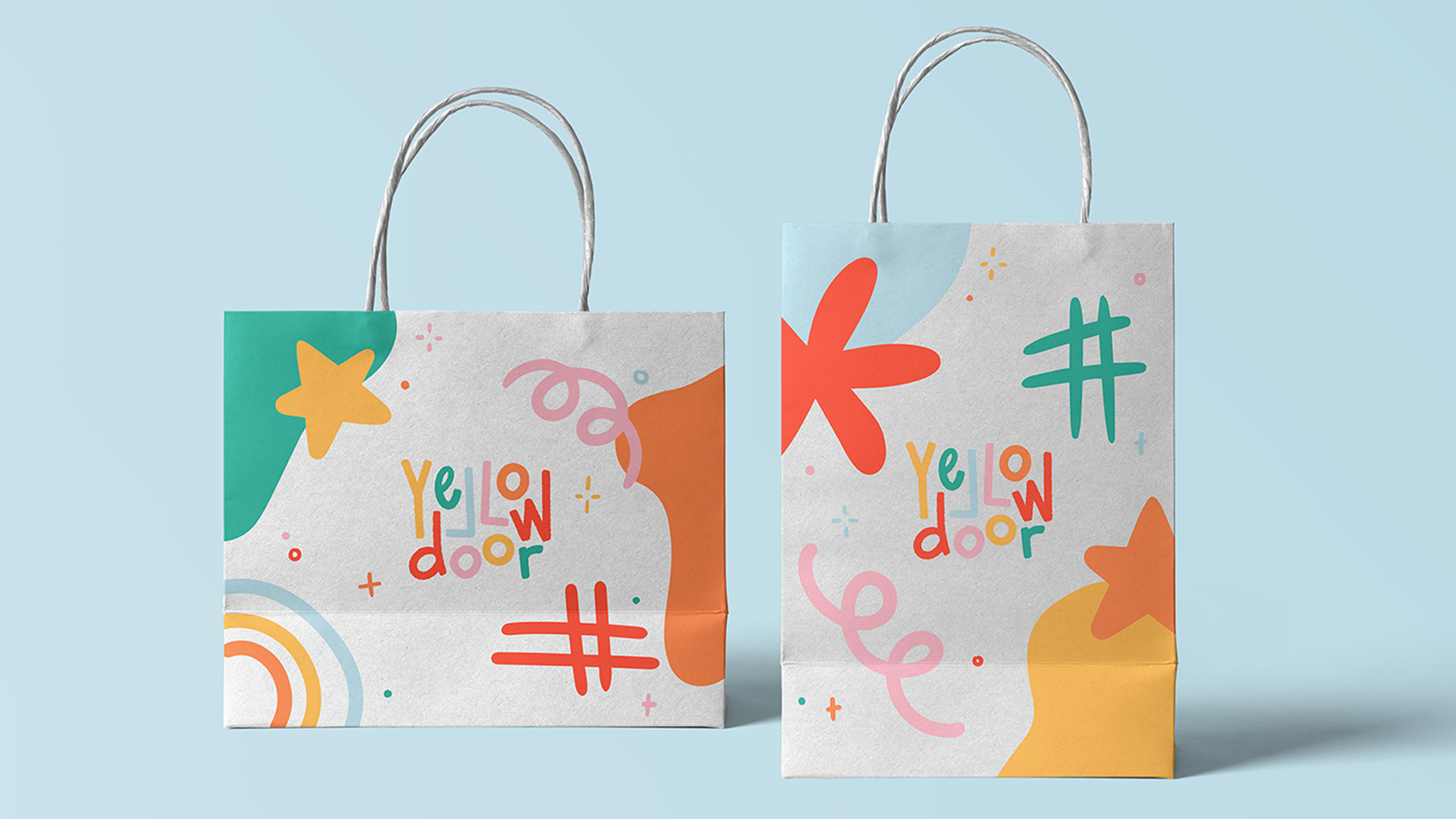 Two white shopping bags with colourful illustrations and logo.