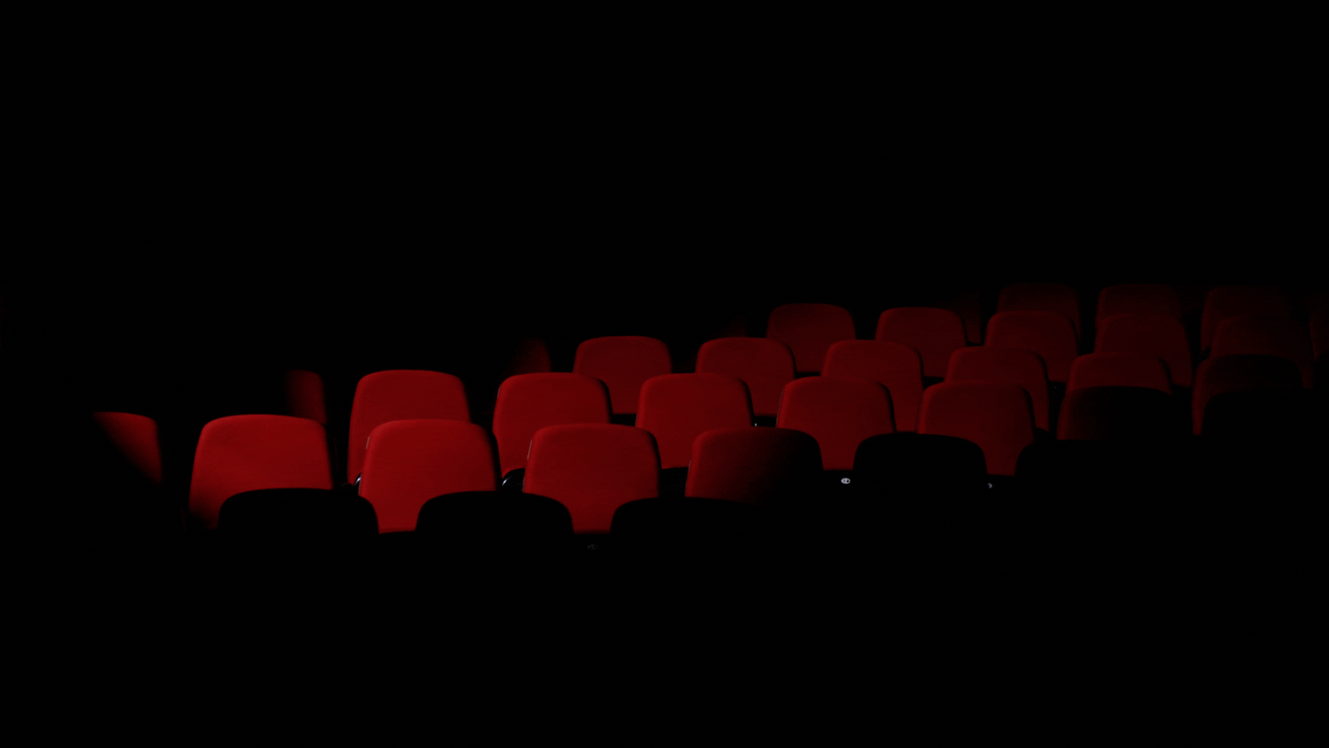 Logo for Hope Theatre superimposed over an image of a dimly lit theatre with red seats.